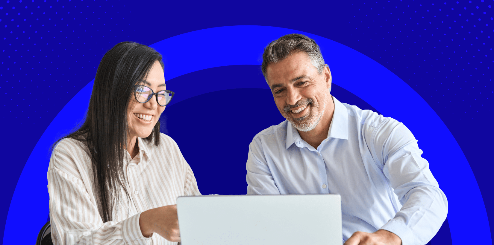 Man and woman looking at laptop with purple background